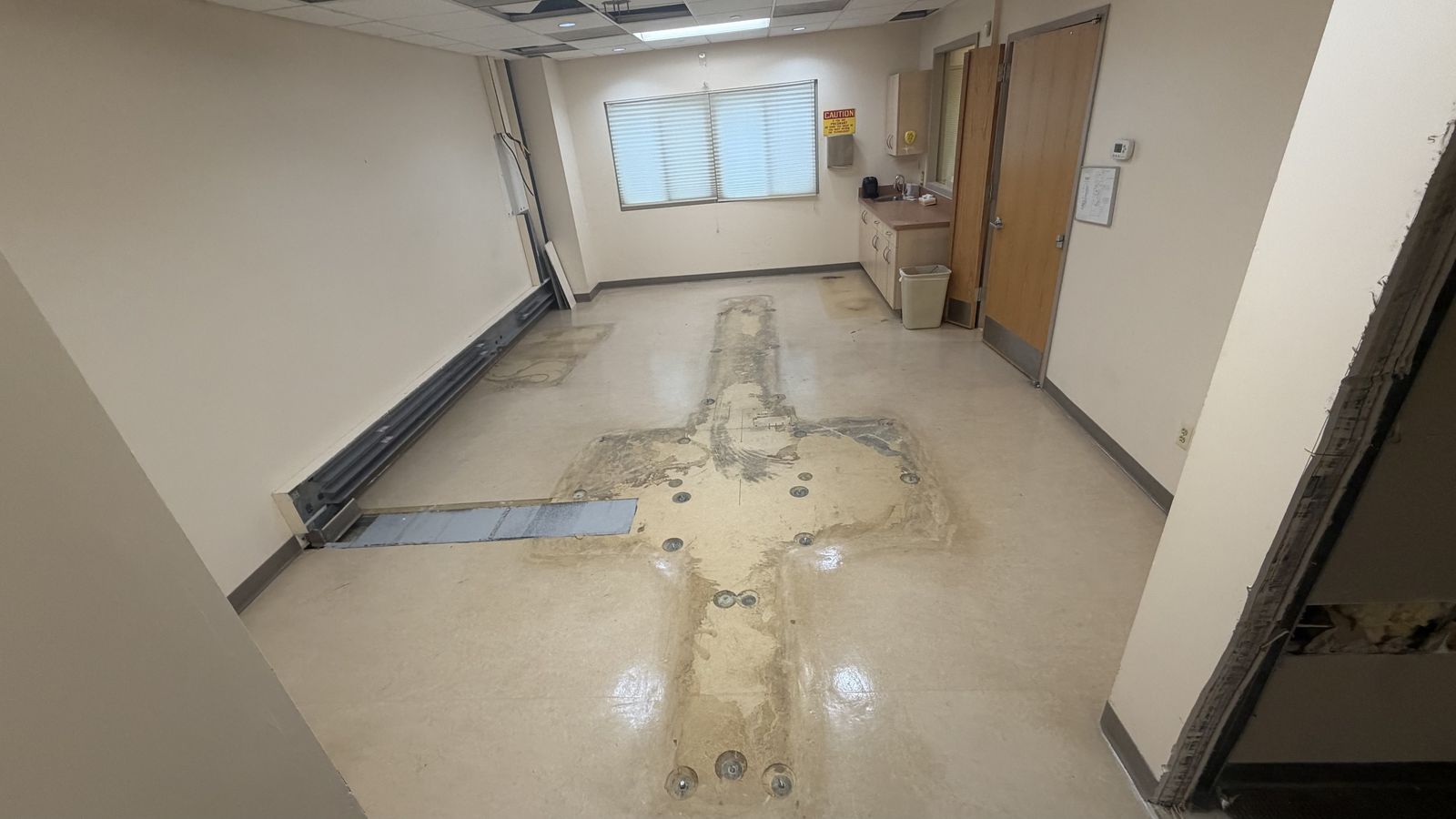 Empty scan room after PET/CT removal, floors intact, single wall opening