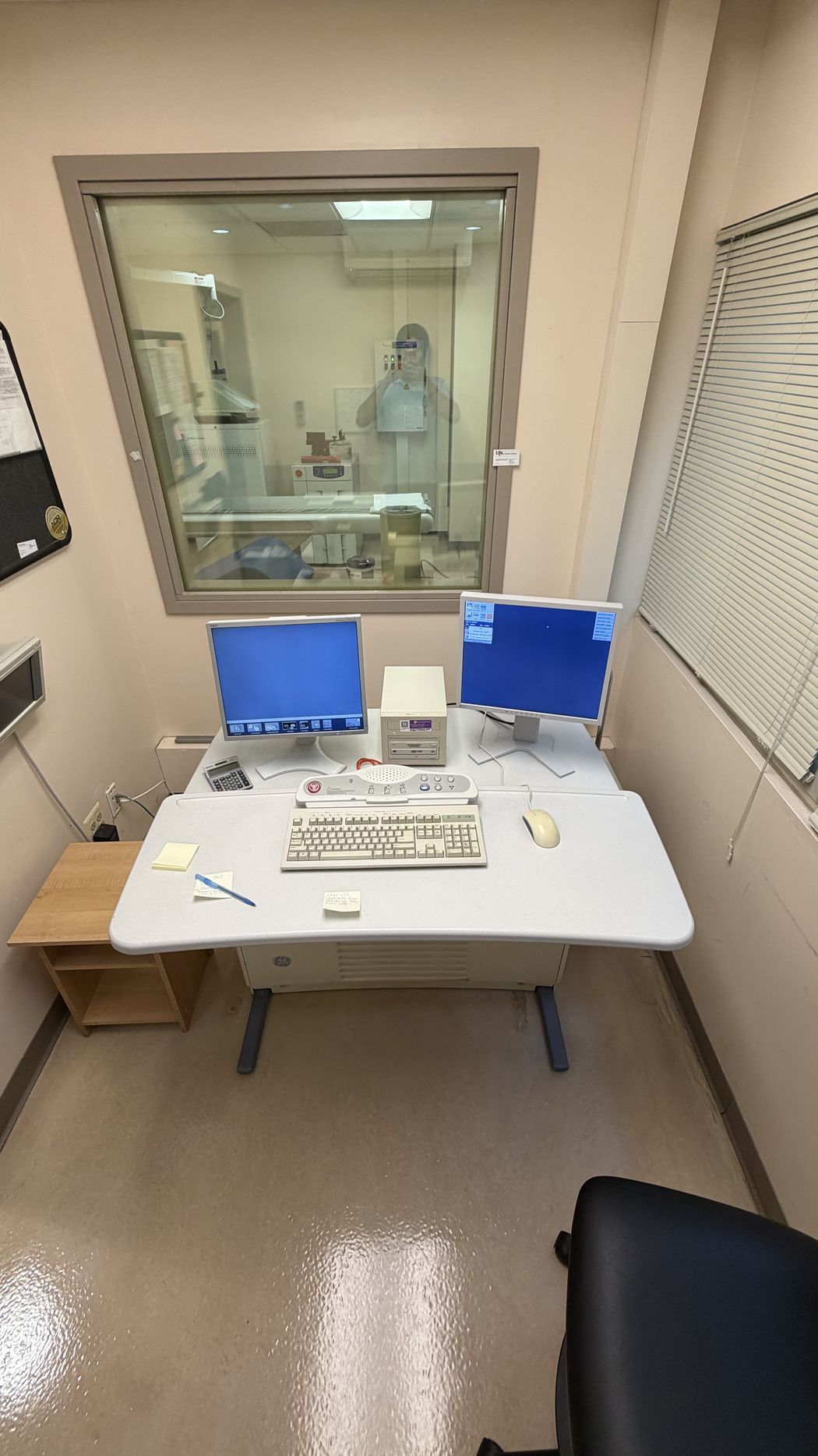 PET/CT operator console room with acquisition workstation and lead glass window